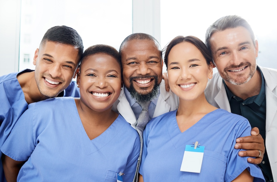 A group photo of diverse, smiling healthcare professionals.