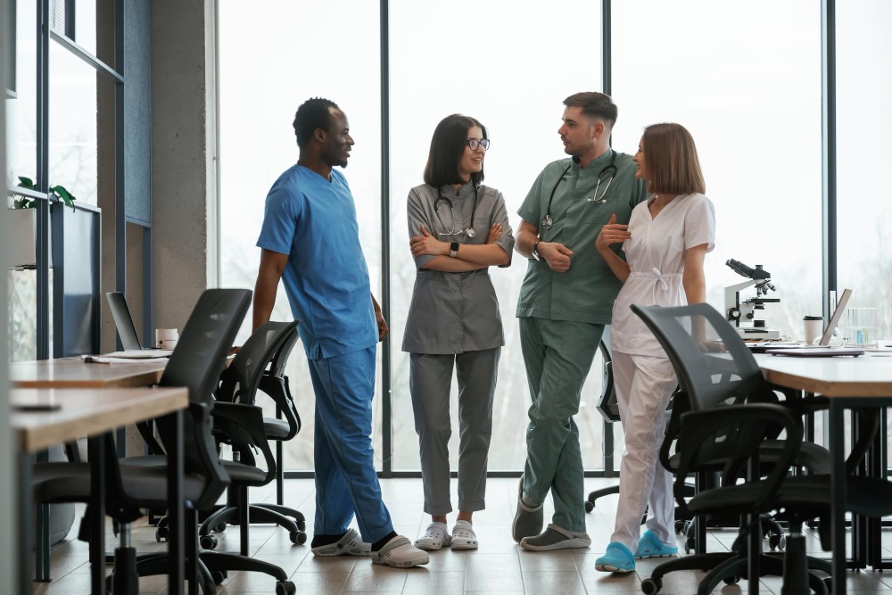 A group of clinicians having a discussion in an office at a medical facility.