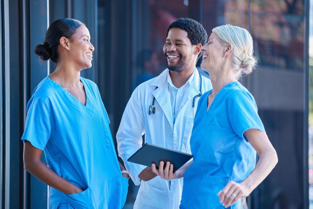 Three happy medical professionals laughing together.