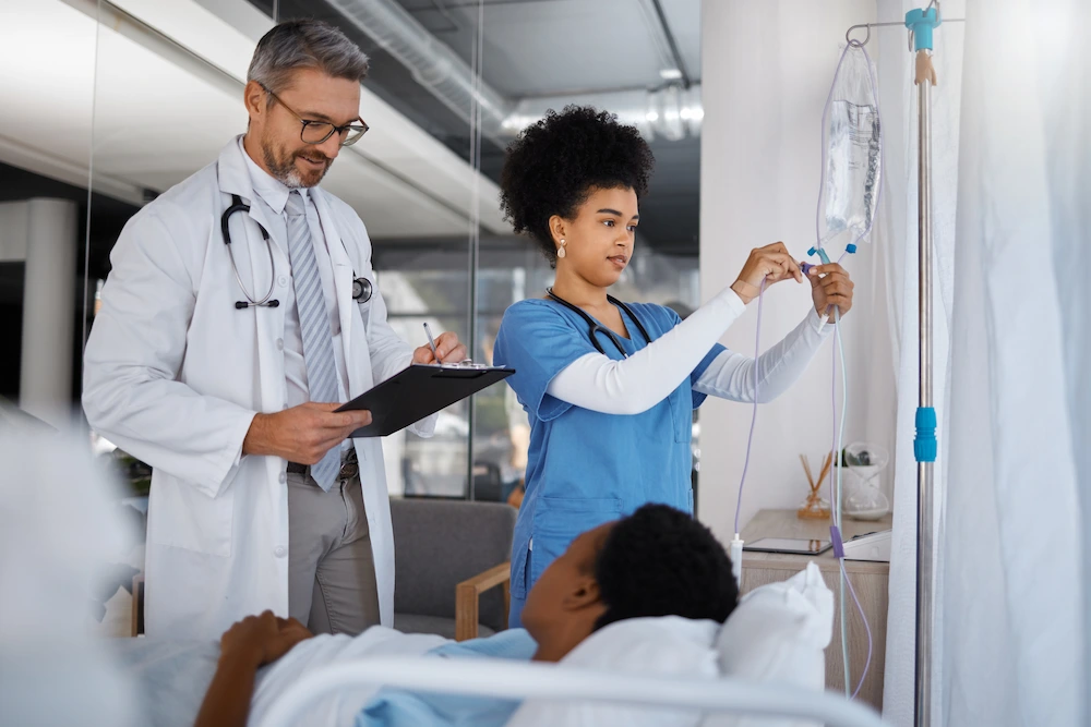 Travel healthcare worker monitoring an IV with doctor.